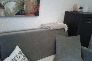 a couch with two pillows and a painting on the wall at KARPACZ SKALNY in Karpacz