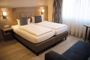 a bedroom with a large bed in a hotel room at Hotel Rosenbusch in Großheubach