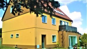 una casa amarilla con techo rojo en Apartmán Seč, en Seč