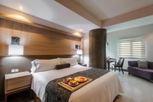 Una habitación de hotel con una cama con una bandeja de comida. en Hotel Real Maestranza, en Guadalajara