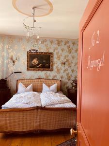 Altes Handelshaus Plauen في بلاوين: غرفة نوم بسرير ودهان على الحائط