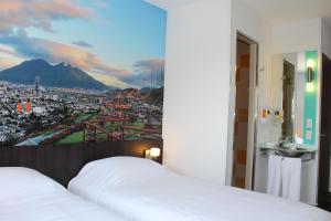 ein Schlafzimmer mit zwei Betten und Blick auf eine Stadt in der Unterkunft Hotel Hi! Fundidora in Monterrey
