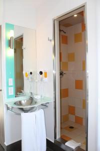 ein Badezimmer mit Waschbecken und Dusche in der Unterkunft Hotel Hi! Fundidora in Monterrey