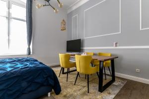 a bedroom with a desk with chairs and a bed at Downtown Apartments Bilk in Düsseldorf