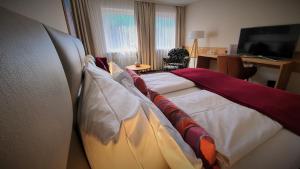 Habitación de hotel con cama con almohadas en Maxhotel, en Lindau