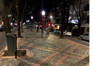 a city street at night with people walking on the sidewalk at Departamento Las Cañitas in Buenos Aires