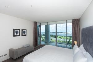 a bedroom with a white bed and a large window at Brighton Shores in Gold Coast