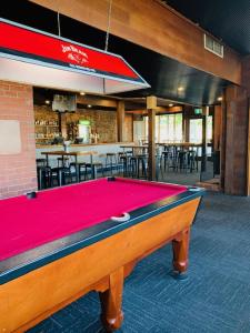 a pool table in front of a restaurant with a bar at Caledonian Hotel Motel in Hamilton