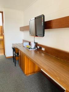 a desk with a flat screen tv on a wall at Caledonian Hotel Motel in Hamilton