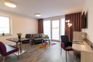 een woonkamer met een bank, een tafel en stoelen bij Hotel & Apartments Leugermann in Ibbenbüren +41 foto's
