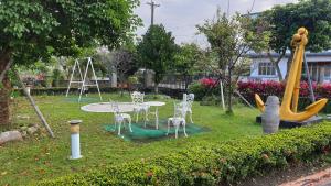 een park met een tafel en stoelen en een speeltuin bij Beauty Monroe B&B-可包棟-150吋投影-唱歌-夏日玩水-烤肉-電動麻將 in Wujie