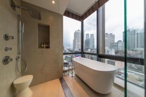 uma banheira na casa de banho com uma grande janela em JR Kyushu Hotel Blossom Shinjuku em Tóquio