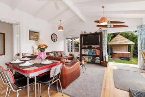 a living room with a table and a couch at Kiwiana Bach - Lake Tarawera Holiday Home in Lake Tarawera