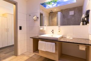 een badkamer met een wastafel en een spiegel bij Hotel & Apartments Leugermann in Ibbenbüren