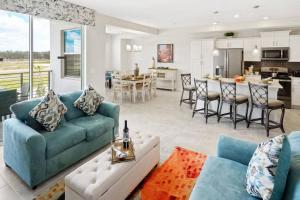 uma sala de estar com um sofá azul e uma cozinha em Amazing Thematic 2BR with Waterpark em Kissimmee
