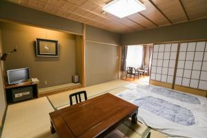 a room with a bed and a table in it at Kyonoyado Kagihei in Kyoto