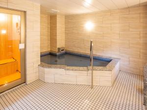 uma banheira de hidromassagem na casa de banho com piso em azulejo em Kuretake Inn Ogaki Ekimae em Ogaki