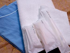 dwa białe ręczniki siedzą na stole w obiekcie Hotel Asahi Grandeur Fuchu w mieście Fuchū