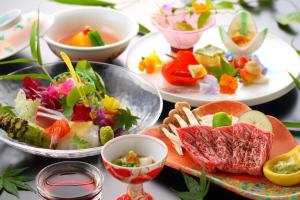 una mesa con platos de comida y tazones de comida en Yufuin Hanayoshi, en Yufu