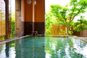 a swimming pool in a house with a large window at Yufuin Hanayoshi in Yufu