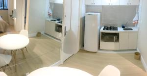uma cozinha com um frigorífico branco e um fogão em Tudo próximo a você em São Paulo