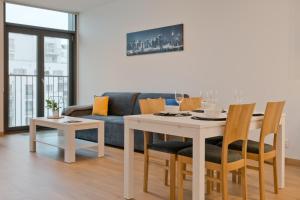 グディニャにあるCITYSTAY Abrahama Gdynia Apartmentのリビングルーム(テーブル、ソファ付)