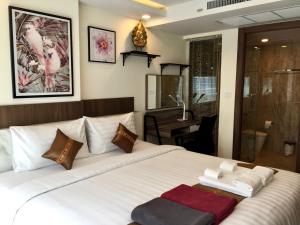a bedroom with a large white bed with towels on it at Luxury Business Suits in Grand Avenue by Pattaya City Estates in Pattaya Central