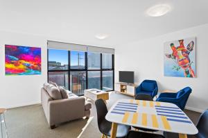 a living room with a table and chairs at Soho 203 in Geelong