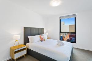 a bedroom with a bed and a window at Soho 203 in Geelong