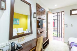 a hotel room with a mirror and a bed at Le Canal Boutique House in Chiang Mai