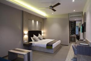 a bedroom with a bed and a couch and a table at Kingston Resort in Kānpur