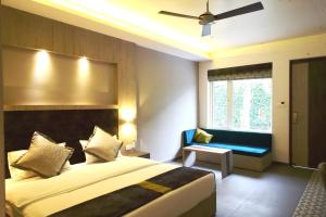 a bedroom with a large bed and a blue bench at Kingston Resort in Kānpur