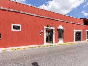 un bâtiment rouge avec un magasin sur son côté dans l'établissement Hotel Rath, à Campeche