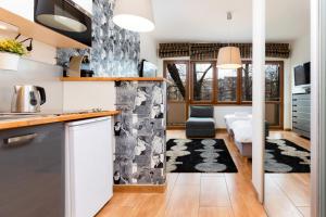 a kitchen and living room with a dining area and a kitchen at Apartments Warsaw Hoża by Renters in Warsaw