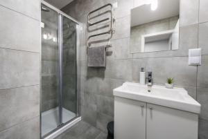 Un baño con lavabo blanco y ducha en Pearl of Sopot, en Sopot 82 fotos más