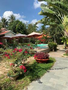 a garden with flowers and plants in a resort at Hiep Thanh Resort in Phú Quốc
