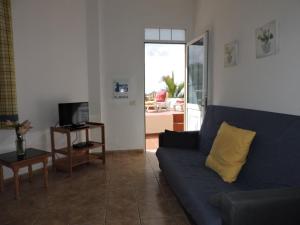 een woonkamer met een blauwe bank en een televisie bij Casas El Monte, en Los Barros in Los Llanos de Aridane