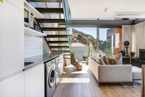 cocina y sala de estar con sofá y escaleras en Always-Power Luxury De Waterkant Loft Retreat, en Ciudad del Cabo