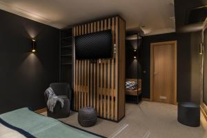 a bedroom with a bed and a wooden closet at Rosslyn Thracia Hotel Sofia in Sofia