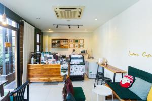 a coffee shop with a counter and tables and chairs at Le Canal Boutique House in Chiang Mai