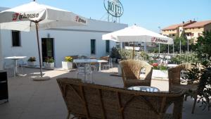 - une table avec des chaises et des parasols sur la terrasse dans l'établissement Hotel Ambrosio La Corte, à Olbia