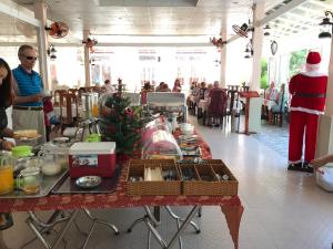 Stolik z świątecznym jedzeniem i mężczyzna w garniturze Santa. w obiekcie Hiep Thanh Resort w Duong Dong