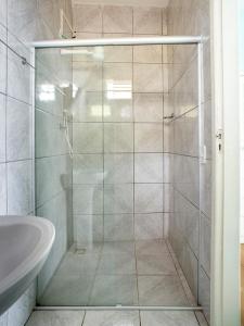 a shower with a glass door in a bathroom at Hotel Lm in Pedro Canário