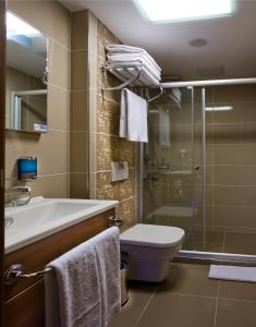 a bathroom with a shower, toilet and sink at Hotel Olimpiyat in Istanbul