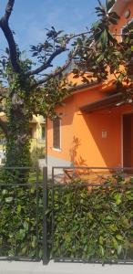 un edificio naranja con una valla delante en New Life, en Carrara