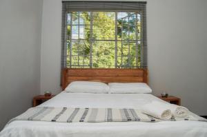 una cama en una habitación con una ventana grande en Kinghurst, City Apartment, en Lusaka