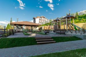 a park with benches and a playground with a slide at Gubernskaya Hotel in Sheregesh