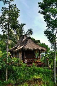 a small hut with a thatched roof on a hill at Satu Lingkung in Tetebatu