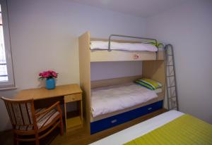 Ce lit superposé se trouve dans un dortoir doté d'un bureau et d'une chaise. dans l'établissement Pansion Boris, à Međugorje