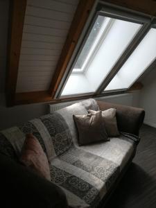 eine Couch mit Kissen vor einem Fenster in der Unterkunft Ferienwohnung im Neubauernweg 3 in Hoppegarten